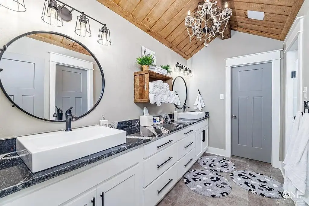 Il bagno con lo specchio tondo e il lavabo d'appoggio