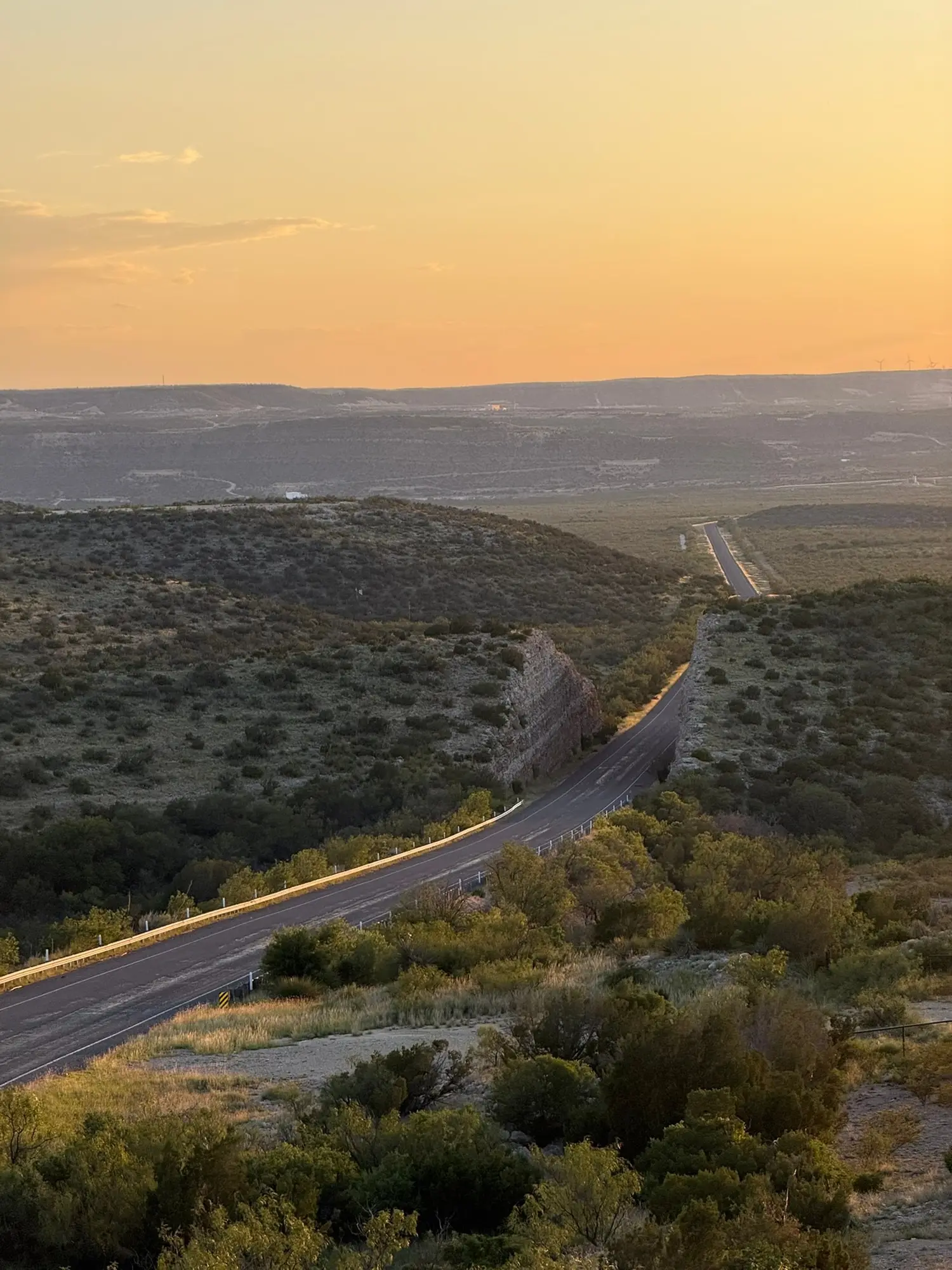Una strada che scende nella valle nella luce dorata del tramonto